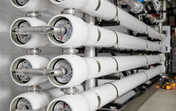 Reverse osmosis system with high-pressure piping inside a mobile water treatment unit